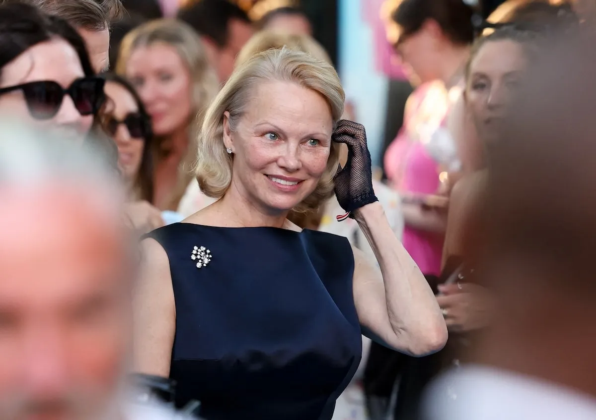 Wearing a navy dress, actor Pamela Anderson attends the premiere of Paramount Pictures' "The Naked Gun"